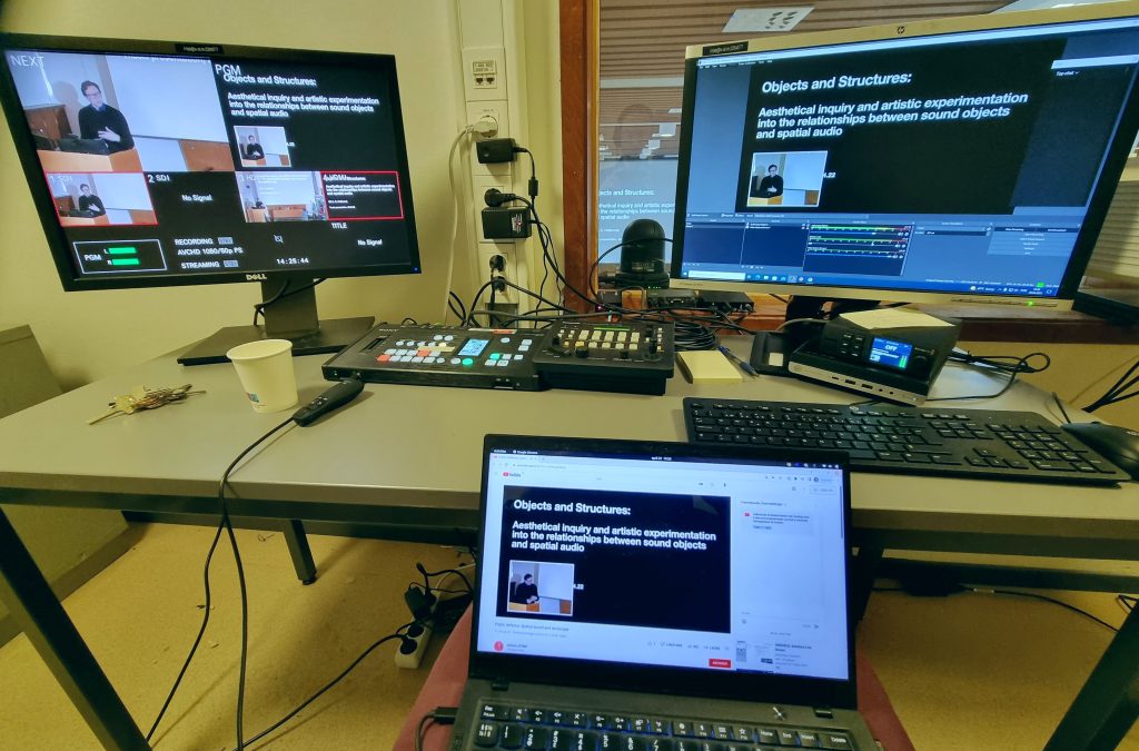 A video from the control room, with a screen of the video mixer’s view to the left, the streaming PC on the right, and my laptop for “monitoring” in the middle.